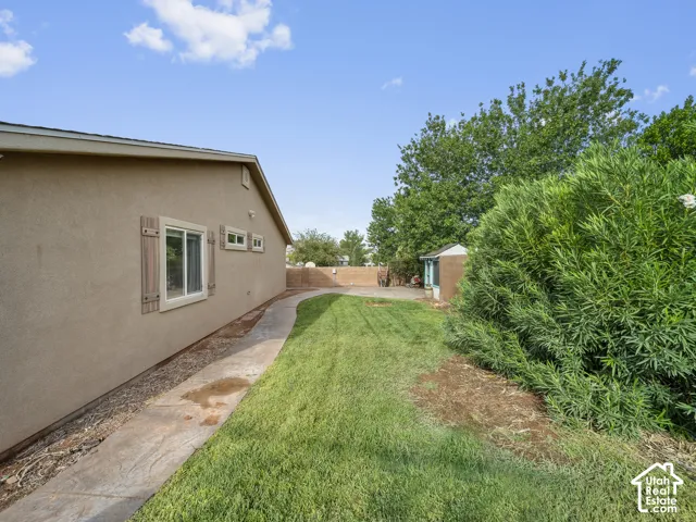 Expansive grassy area with a concrete pathway and mature landscaping