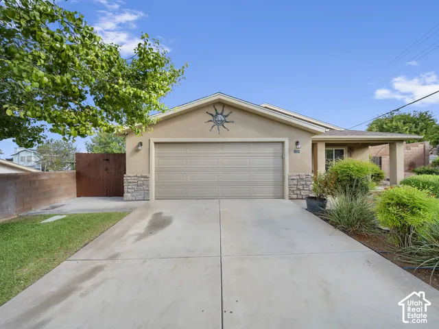 Stucco exterior with stone accents, covered entry, and an attached two-car garage