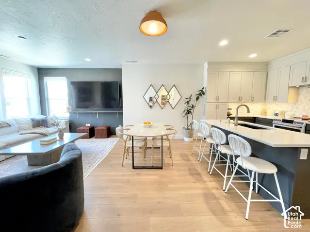 Open-concept living space with wood-finish flooring, recessed lighting, and a modern kitchen island