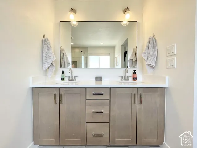 Double vanity with a white countertop and integrated sinks, complemented by a large framed mirror