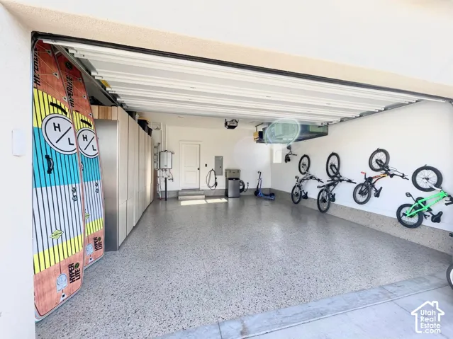 Garage featuring extensive built-in cabinetry, durable epoxy flooring, and a dedicated utility sink