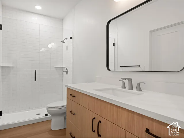 Bathroom featuring a wood-finish vanity with a white countertop, an undermount sink, and a rectangular mirror with a black frame