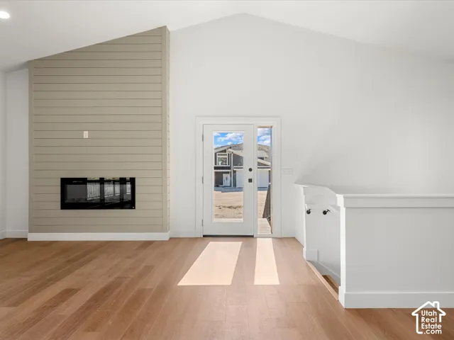Vaulted ceiling with an integrated fireplace and shiplap-style accent wall