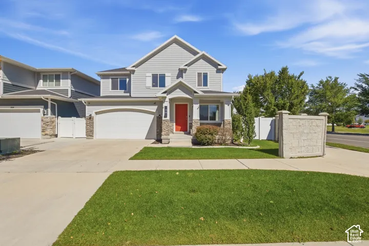 Two-story exterior with siding and stone accents, featuring a two-car garage