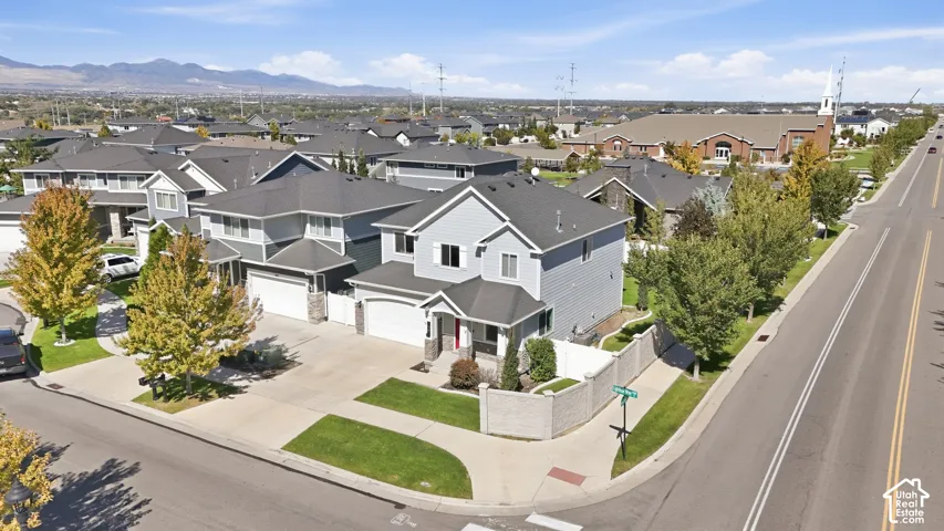 Corner lot residence with two-story design, attached garage, and stone accent facade