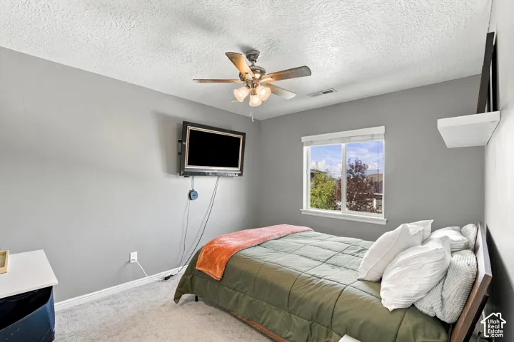 Recessed window with white trim, wall-mounted television, ceiling fan with integrated lighting, and a floating wall shelf