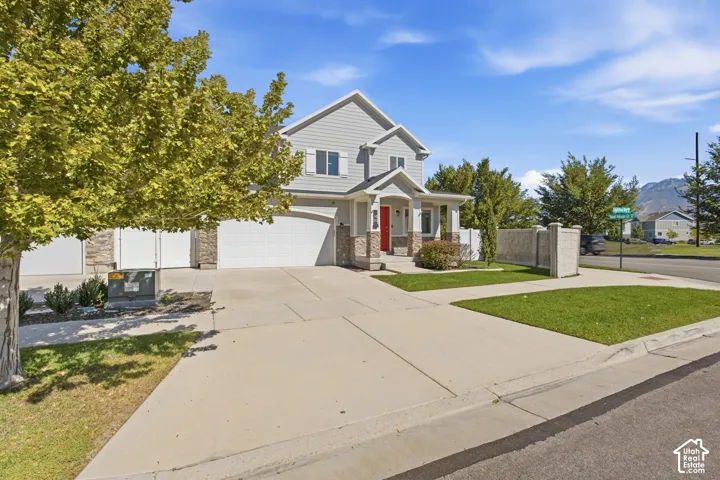 Two-story residence with light gray siding and stone accents