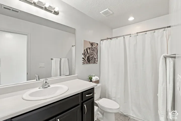 Vanity with an oval undermount sink, dark wood-finish cabinetry, and a large wall-mounted mirror