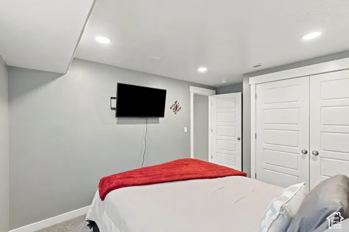 Recessed lighting, wood-finish interior doors, light gray wall paint, and gray carpeted flooring