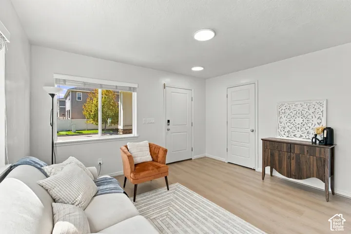 Recessed ceiling lighting, wood-finish flooring, white walls, and white trim throughout
