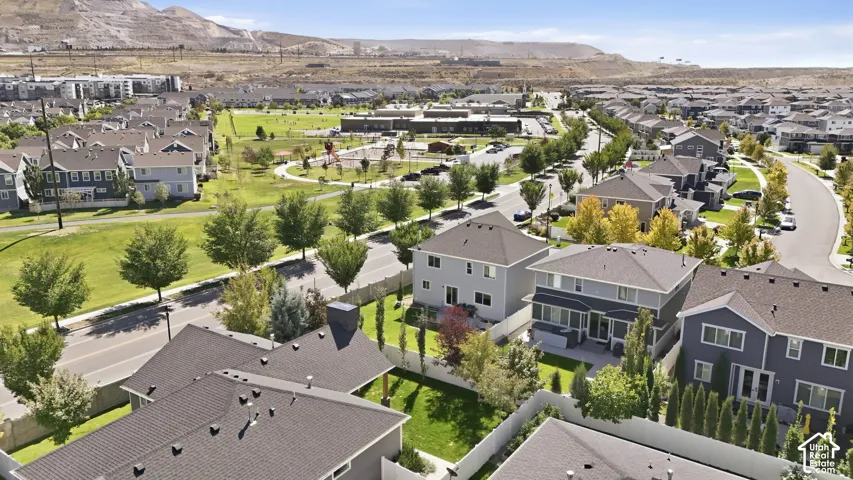 Residential neighborhood with mature trees, paved streets, and a prominent green space with walking paths