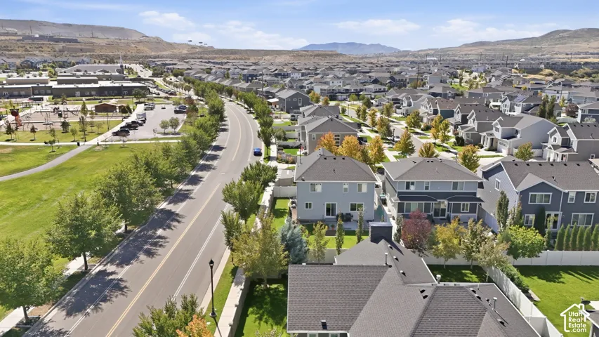 Expansive suburban community with numerous residences, mature trees, and mountainous surroundings