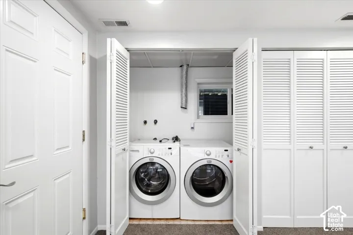 Laundry area with louvered bi-fold doors, white paneled door, and built-in overhead lighting