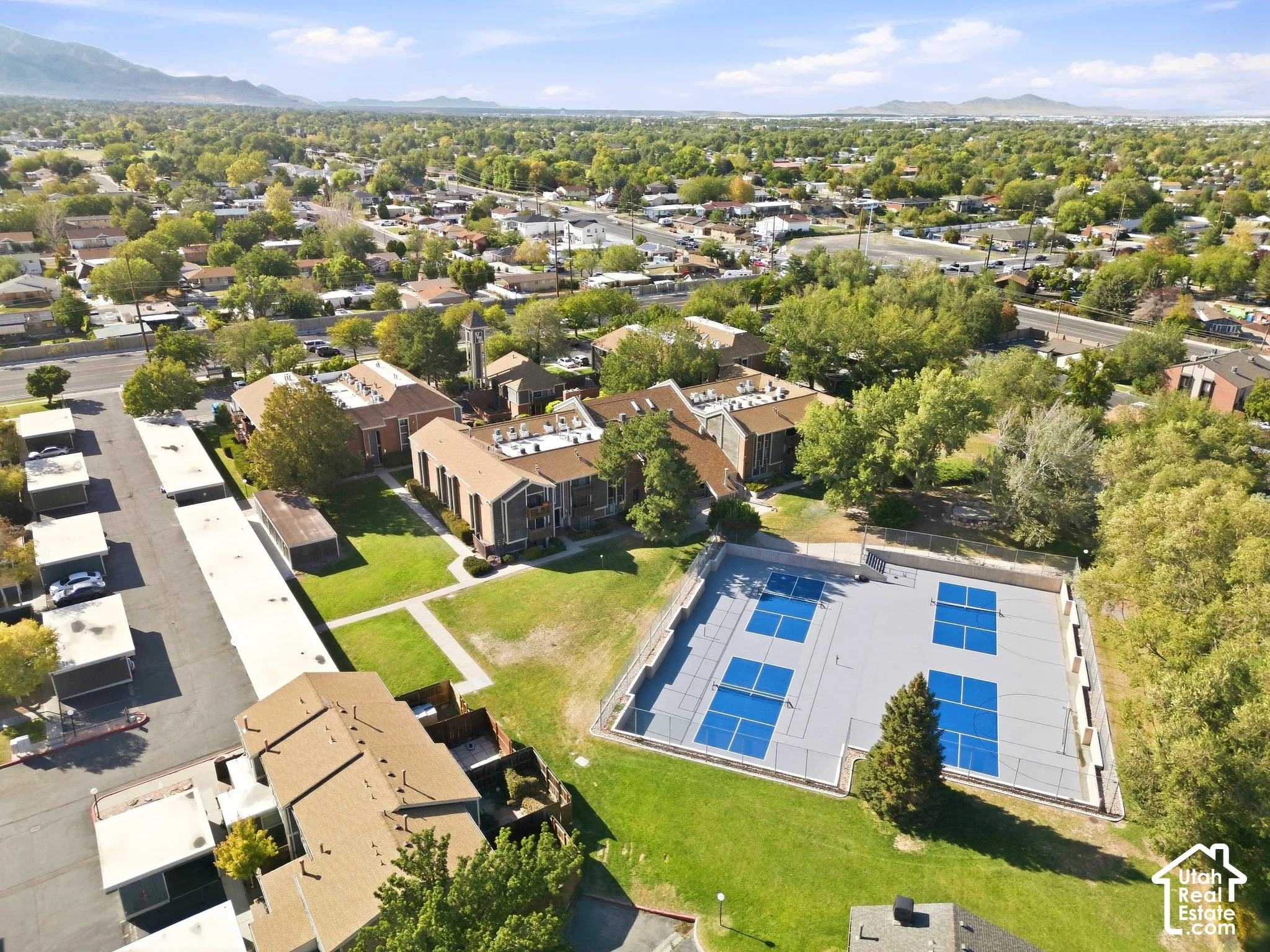 Expansive grounds featuring multiple residential buildings, covered parking, and large multi-sport courts
