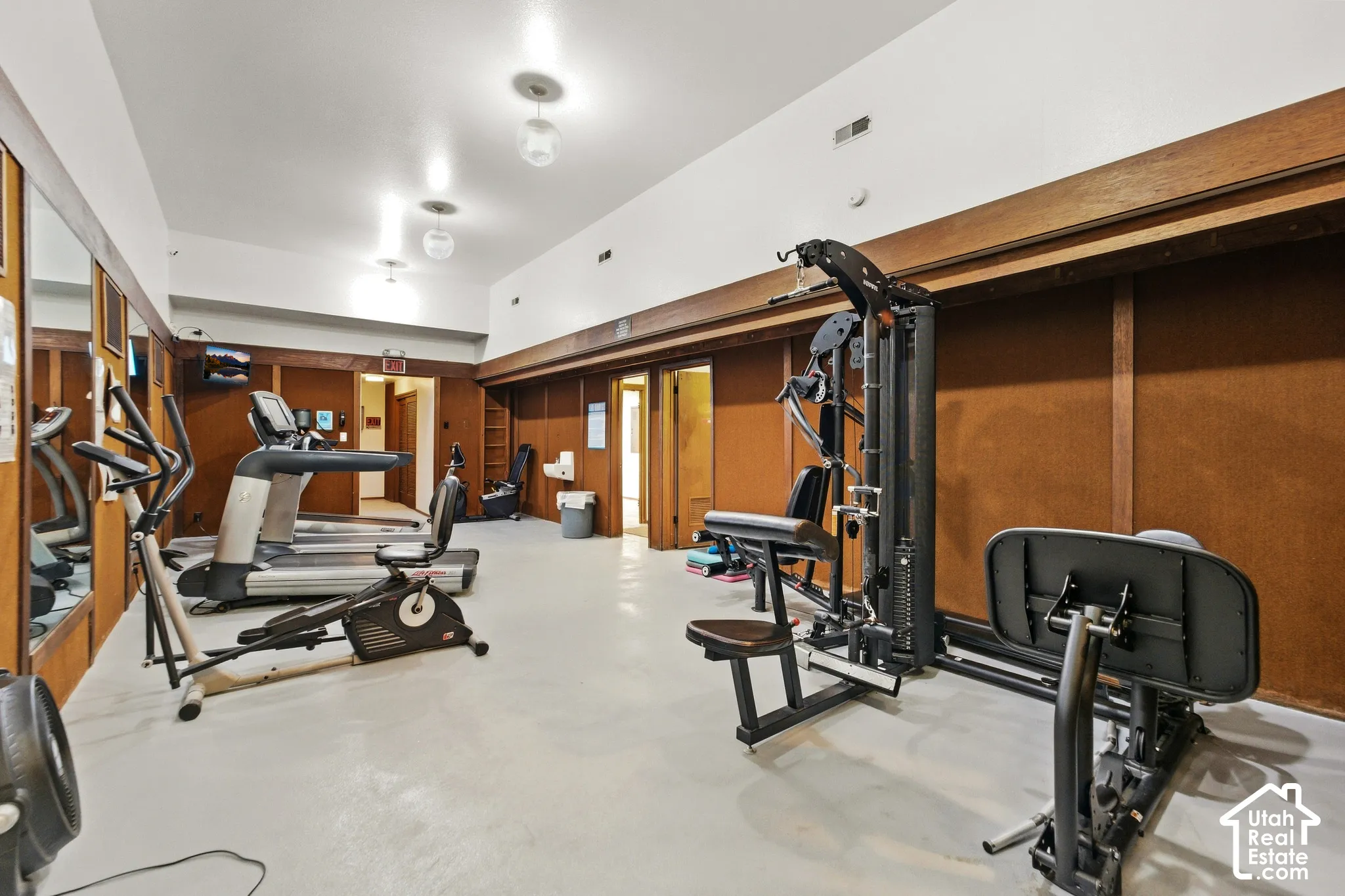 Recreational room with wood paneling, recessed lighting, and a mirrored wall