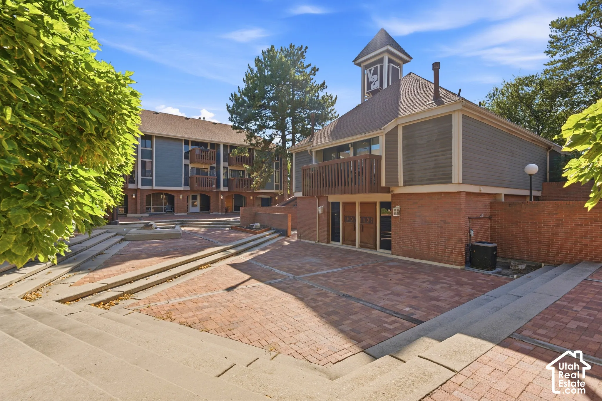 Brick facade with multi-level architecture, wood siding, and gabled roofs