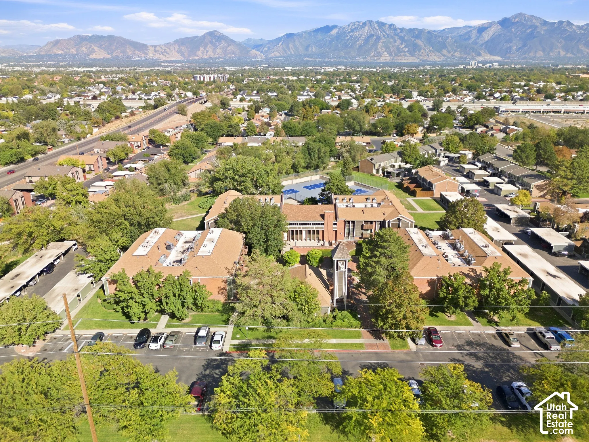 Expansive community featuring multiple buildings, surface parking, and a prominent mountain backdrop