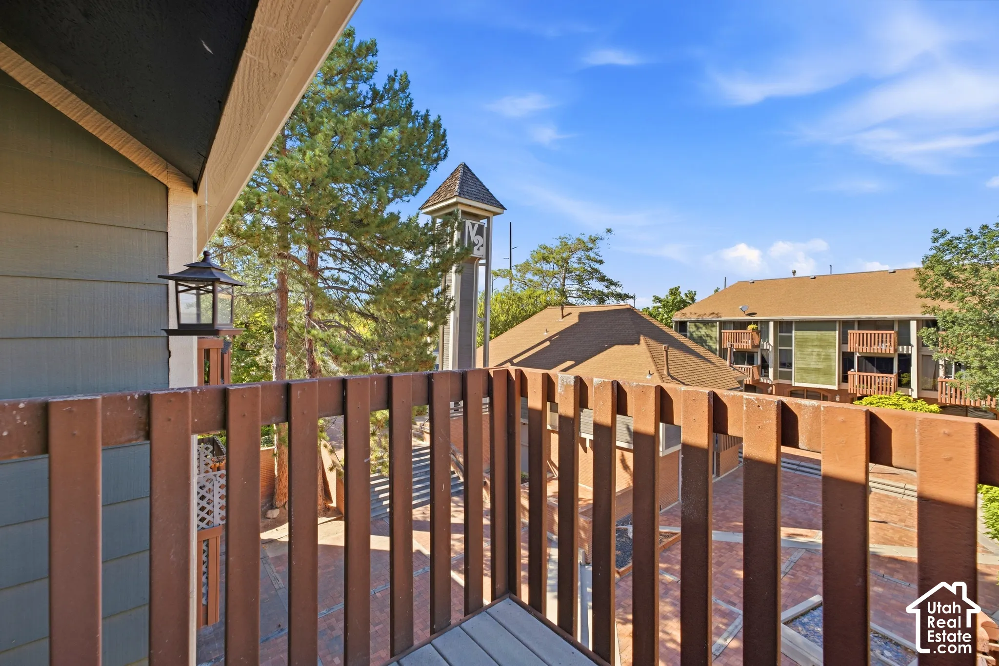 Elevated composite deck with horizontal wood-finish railings overlooking manicured grounds and mature landscape