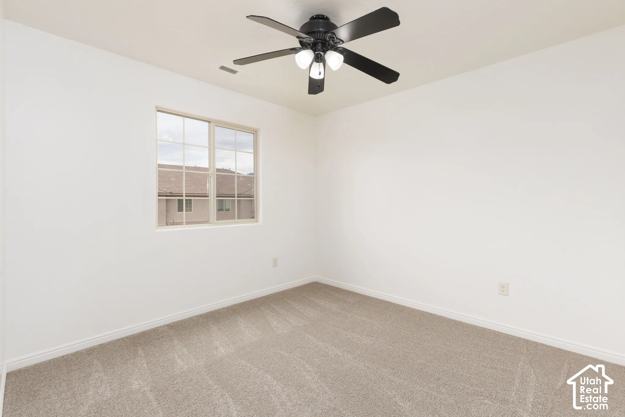 Recessed window, ceiling fan with integrated lighting, and neutral carpeting