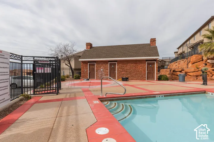 Swimming pool with integral steps and a surrounding concrete deck featuring red accents