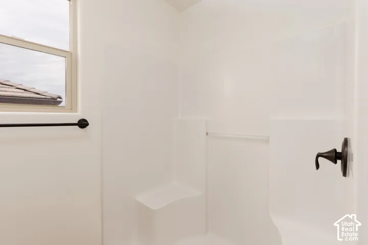 Shower enclosure with a built-in bench, oil-rubbed bronze fixtures, and a window