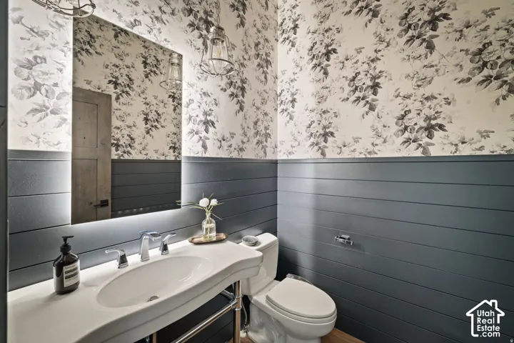 Contemporary vanity with a curved basin, chrome fixtures, and an illuminated mirror