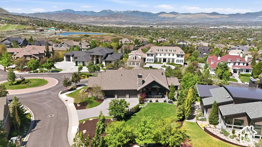 Elegant residential property featuring a stone and siding exterior, a multi-car garage, and a lush green lawn