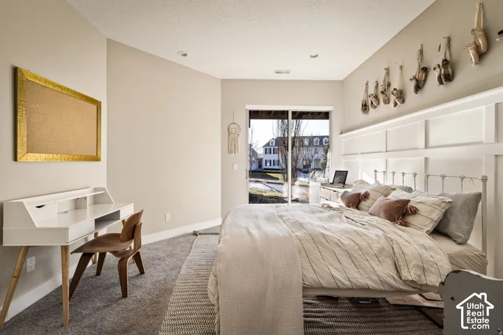 Sliding glass door, wall paneling, recessed lighting, neutral wall color, and carpet flooring