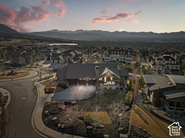 Large residence with a substantial driveway, multi-car garage, and expansive landscaping