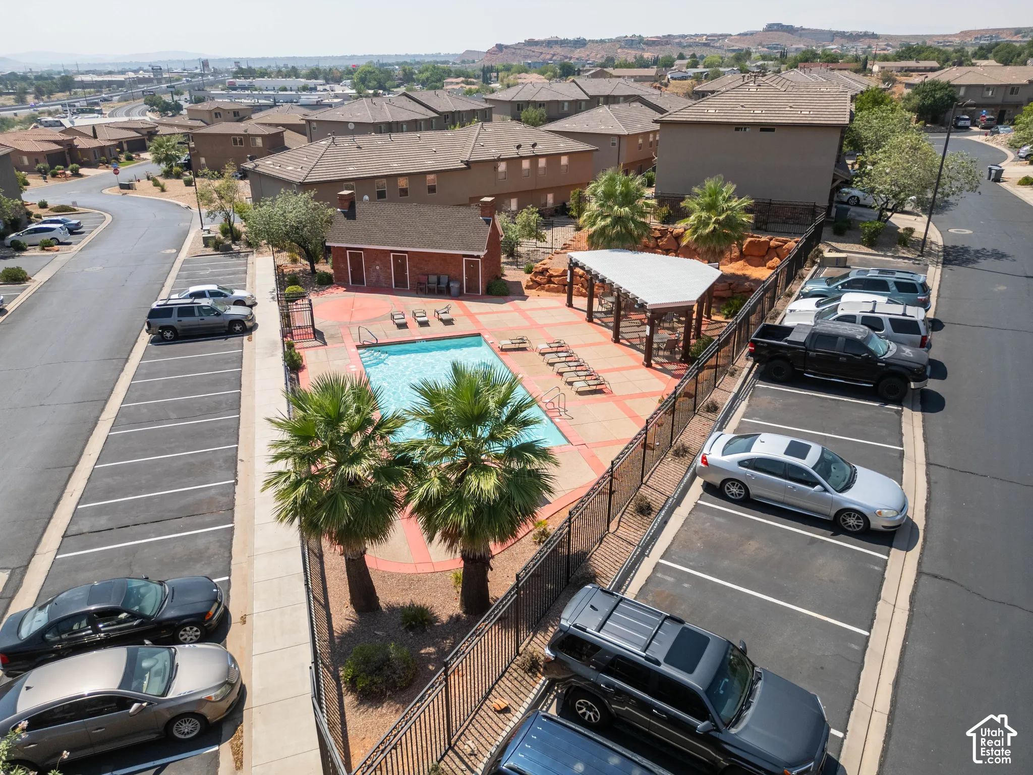 Community swimming pool with a red brick perimeter and a covered outdoor seating area
