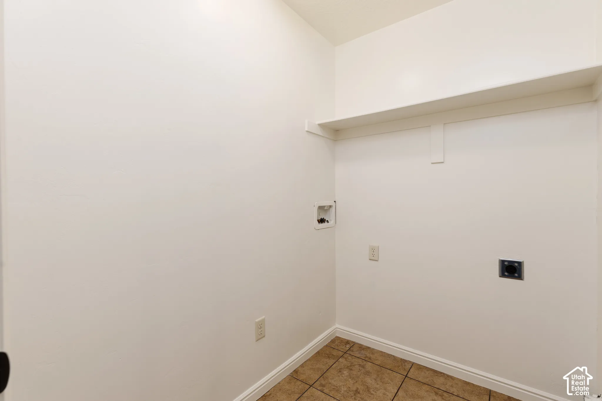 Utility area featuring a built-in shelf and tile flooring