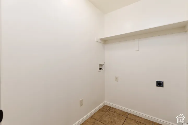 Utility area featuring a built-in shelf and tile flooring
