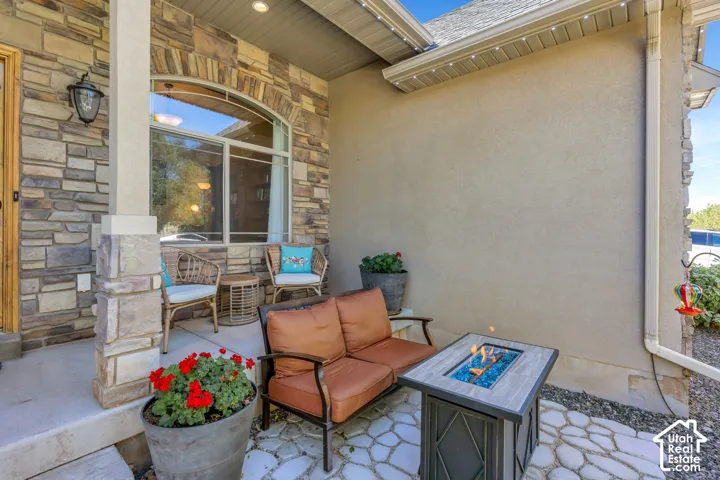 Stone veneer exterior with stucco accents, featuring an arched window and covered patio