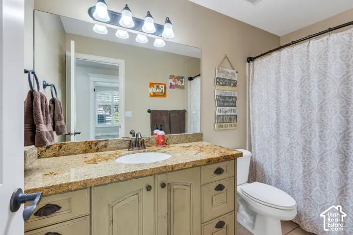 Vanity with an integrated sink, stone countertop, and wood-finish cabinetry