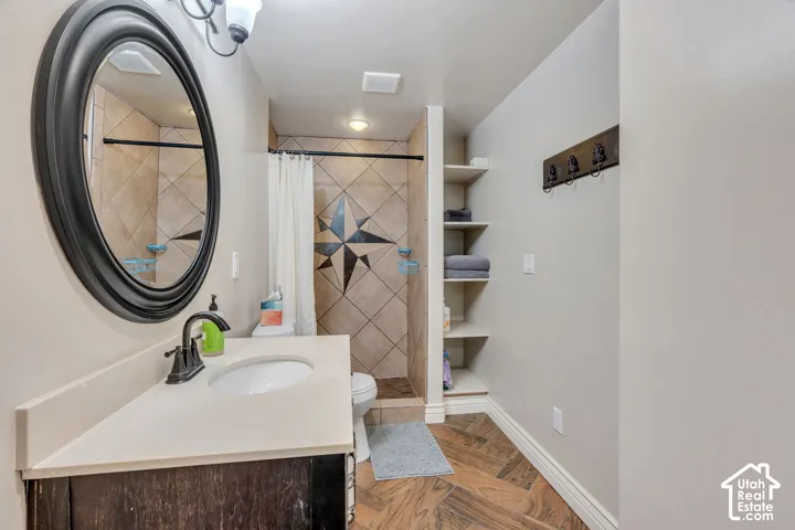 Vanity with a round sink, bronze-finish faucet, and light-colored countertop