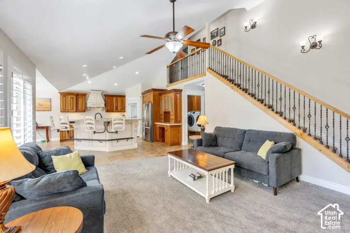 Vaulted ceilings with recessed lighting, ceiling fan, and decorative wall sconces