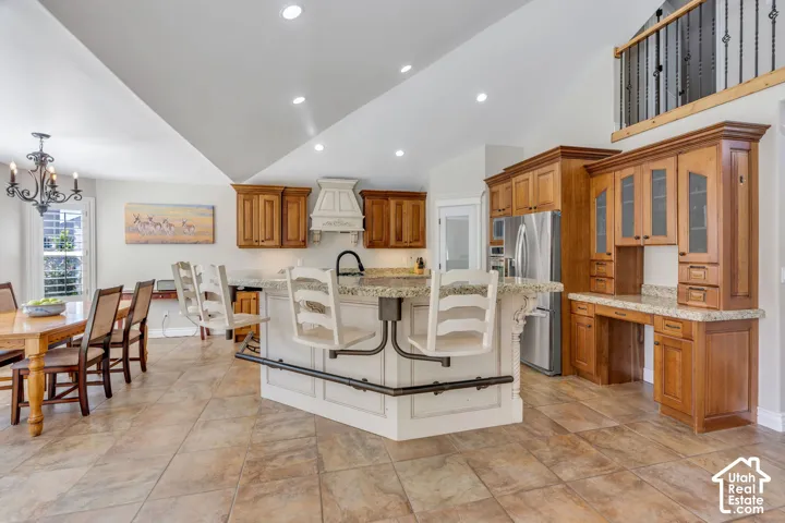 Vaulted ceilings, recessed lighting, and tile flooring