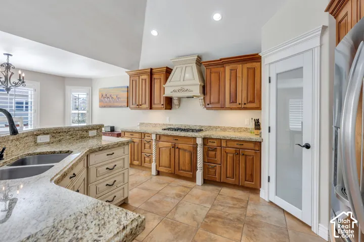 Kitchen featuring wood-finish cabinetry, light-toned countertops, and tile flooring