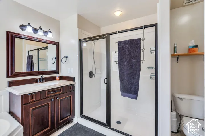 Dark wood-finish vanity with a light-toned countertop, framed mirror, and a three-light fixture