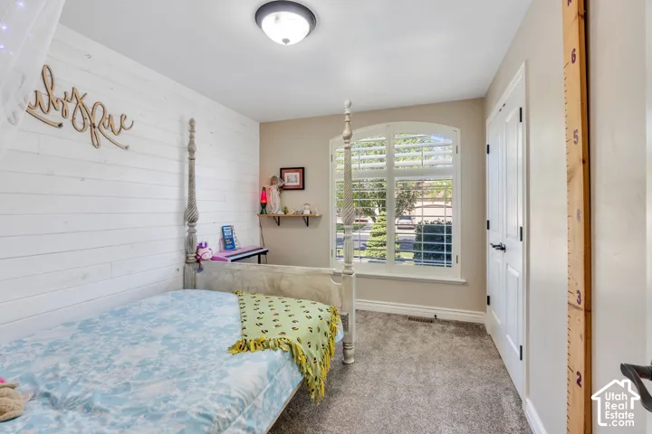 Shiplap accent wall, arched window with plantation shutters, neutral paint, built-in wall shelf, and flush-mount ceiling light