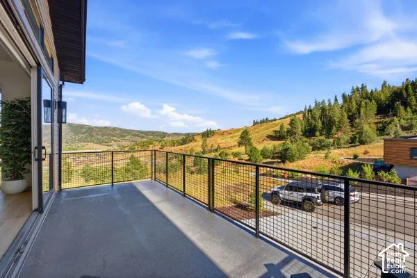 Spacious balcony with black metal grid railing, large sliding glass doors, and recessed exterior lighting. The photos are renderings only - these photos are for a similar unit in Discovery Ridge. Not this actual model.