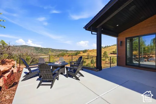 Expansive concrete patio with metal railing and natural landscaping. The photos are renderings only - these photos are for a similar unit in Discovery Ridge. Not this actual model.
