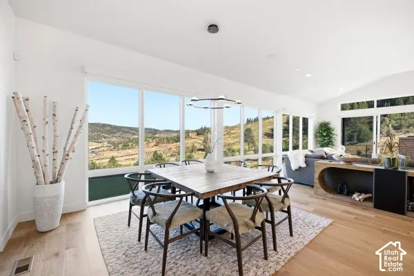 Expansive floor-to-ceiling windows, vaulted ceilings, wood-finish flooring, and a modern ceiling fixture. The photos are renderings only - these photos are for a similar unit in Discovery Ridge. Not this actual model.
