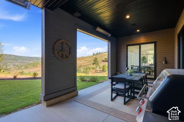 Covered outdoor patio with recessed lighting, integrated outdoor heater, exterior sliding glass door, and expansive landscape. The photos are renderings only - these photos are for a similar unit in Discovery Ridge. Not this actual model.