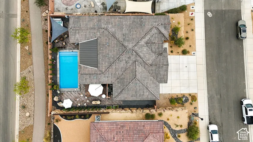 Tiled roof residence featuring a rectangular swimming pool, a patio area, and xeriscaped landscaping