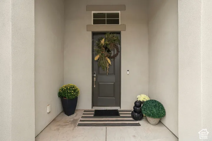Recessed entry with a solid panel door, transom window, and textured stucco finish