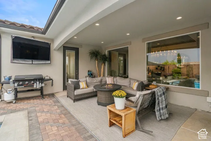 Covered patio with recessed lighting, large glass windows, and a glass-paneled door