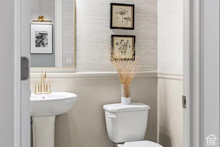 Pedestal sink with brass-finish faucet and mirror with brass-finish frame