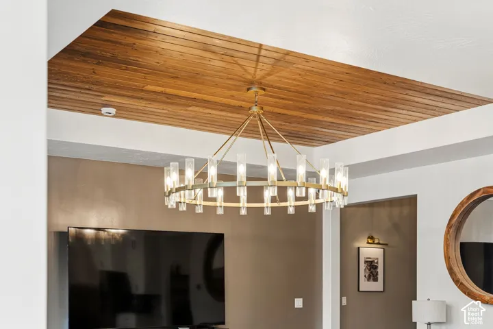 Recessed wood-panel ceiling feature with a contemporary chandelier