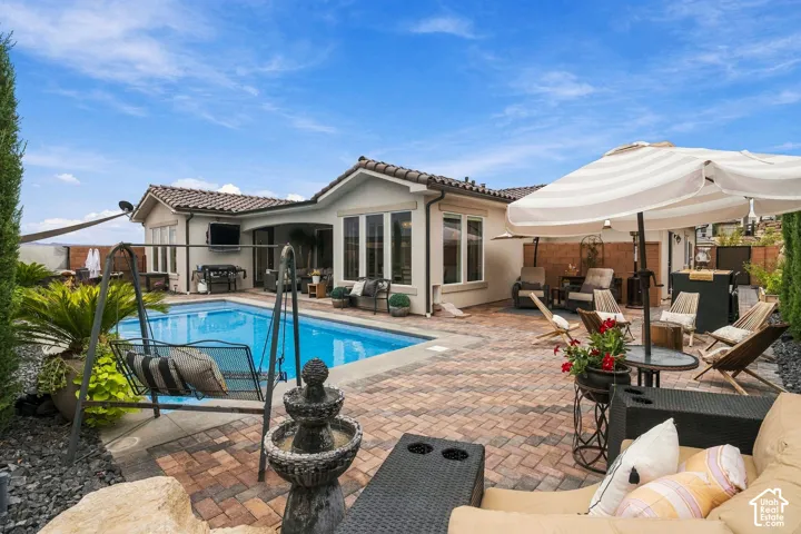 Outdoor pool with a paver patio and a built-in outdoor kitchen